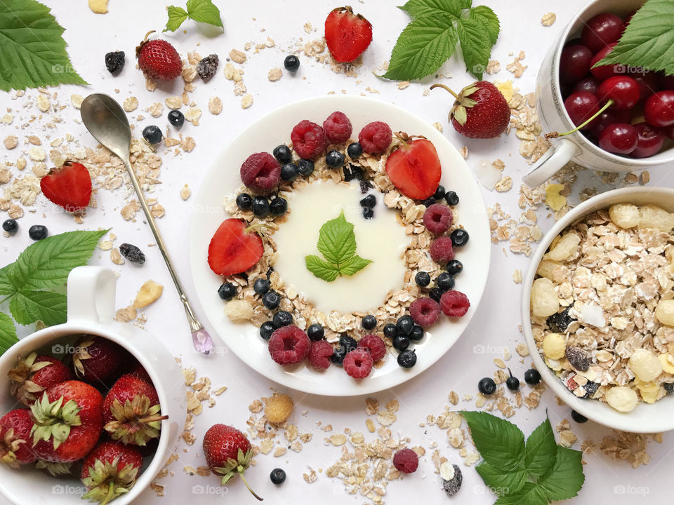 Overheard view of healthy breakfast- cereals, yogurt and fresh ripe berries: strawberries, raspberries, cherries, blackberries 