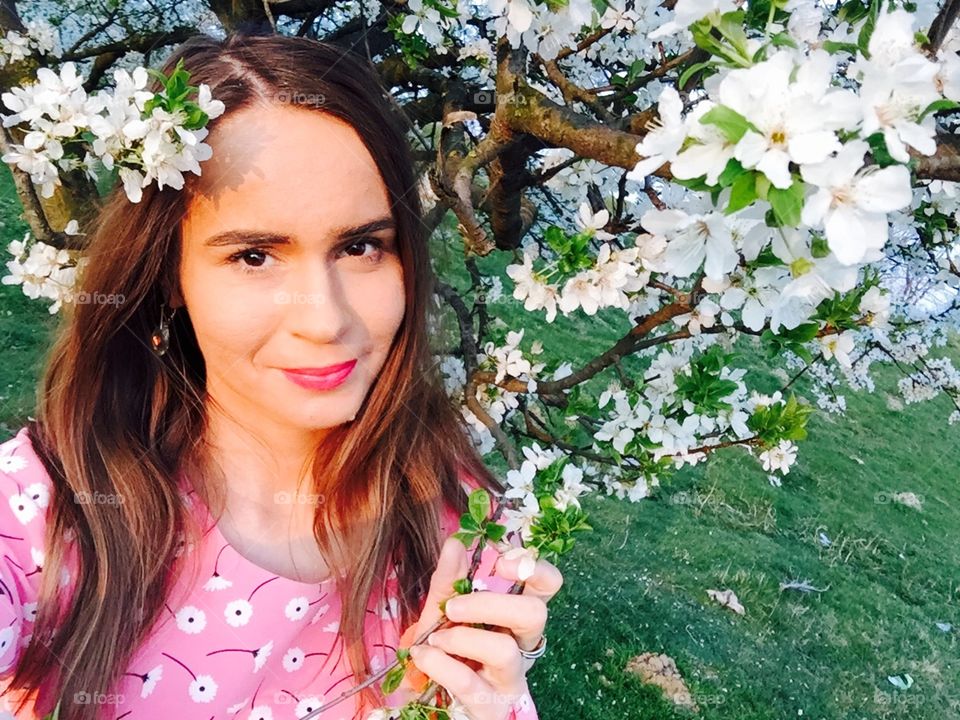 Spring portrait of woman surrounded by blooming trees