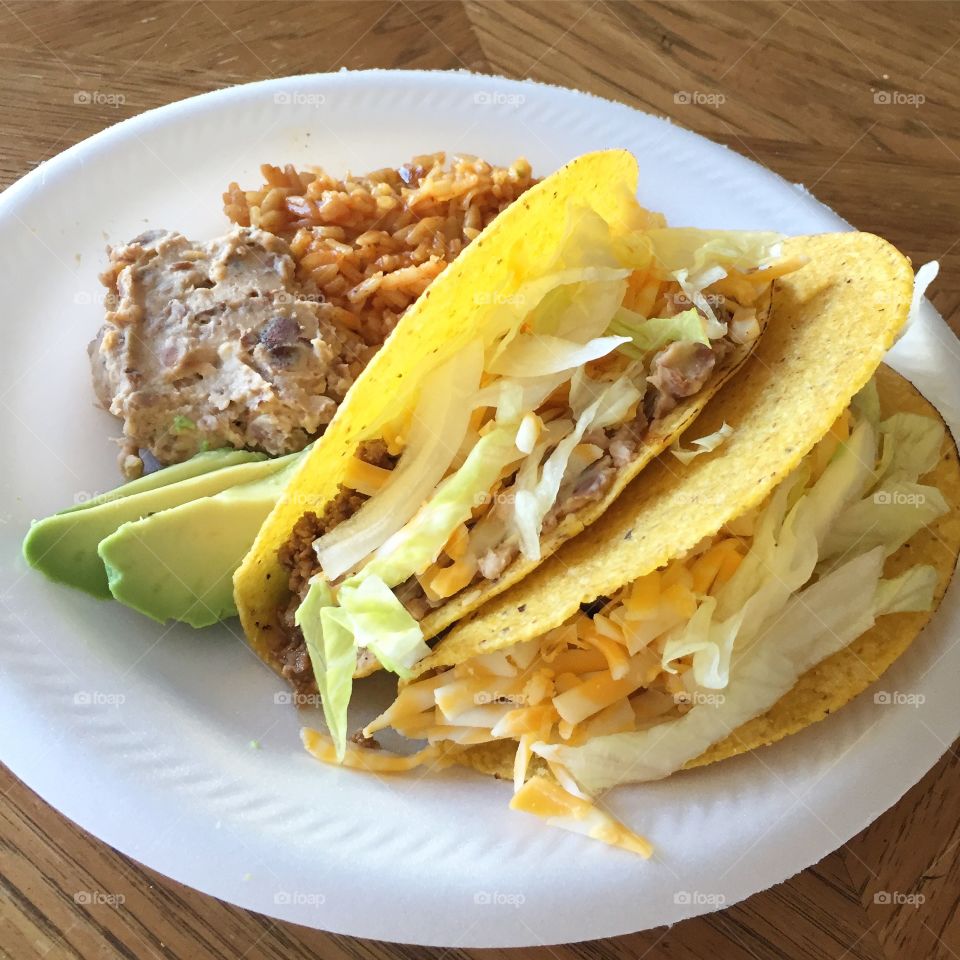 The simplicity of this dish is what makes it amazing!A crunchy beef taco with sides of Mexican rice, refried beans and slices of avocado!