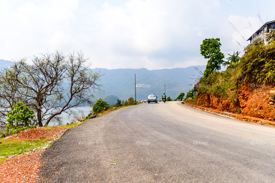 Photograph of empty road with hill in surrounding near Pokhara Lake at Kathmandu Nepal. Snap in portrait, landscape, wide screen style. Vintage film look. Vacation Freedom, Simplicity Concept.