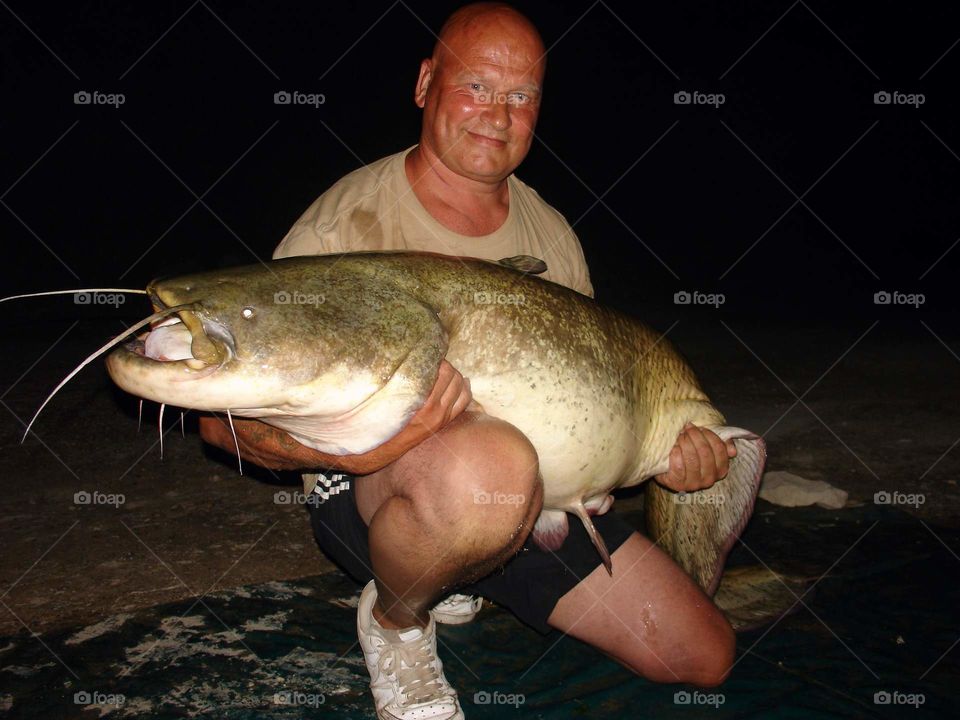 Smiling man holding large fish