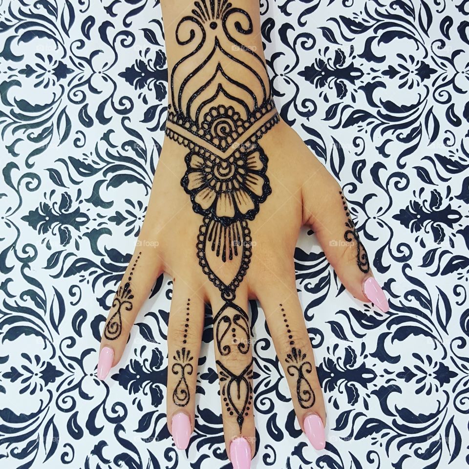 a freestyle hand henna with beautiful pink nails