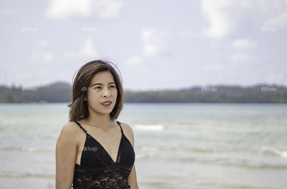 Portrait of Asian woman wearing a swimsuit background sea and sky