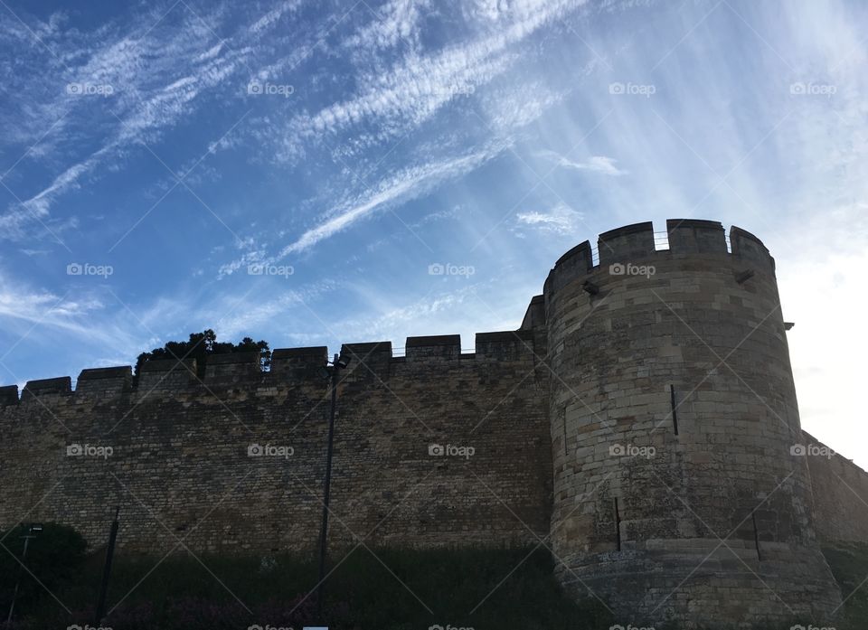 Exterior view of the north facing wall of Lincoln castle in the summer against a wispy cloudy sky