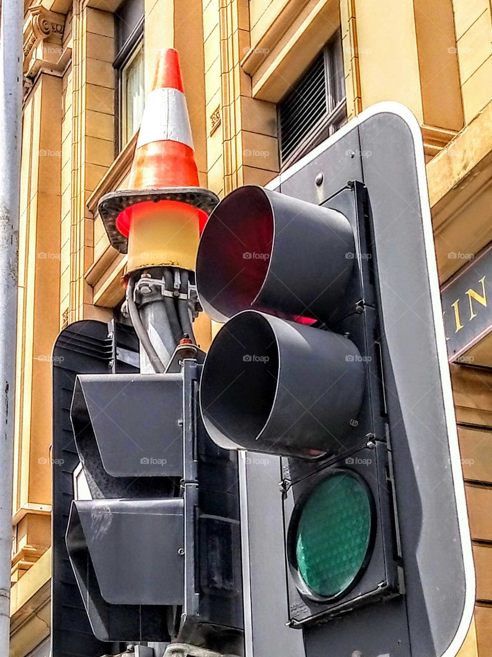 traffic cone on top of traffic lights
