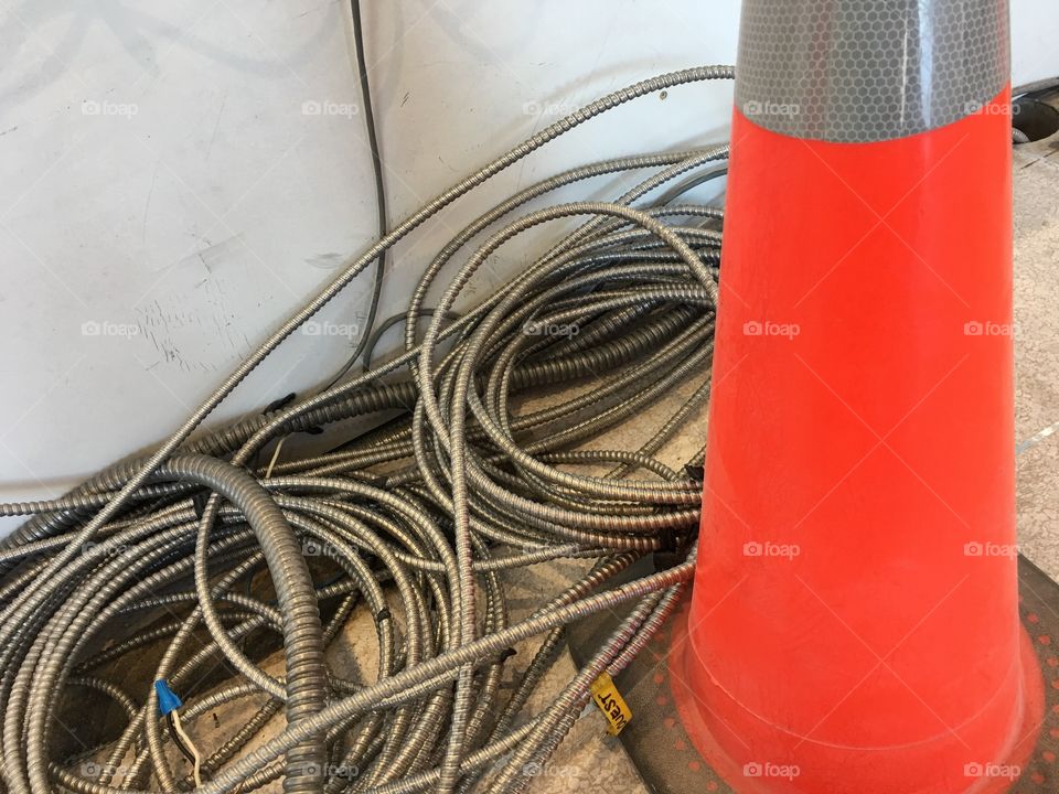 Orange Construction cone indoors with spiral Metal wires during renovation in building 