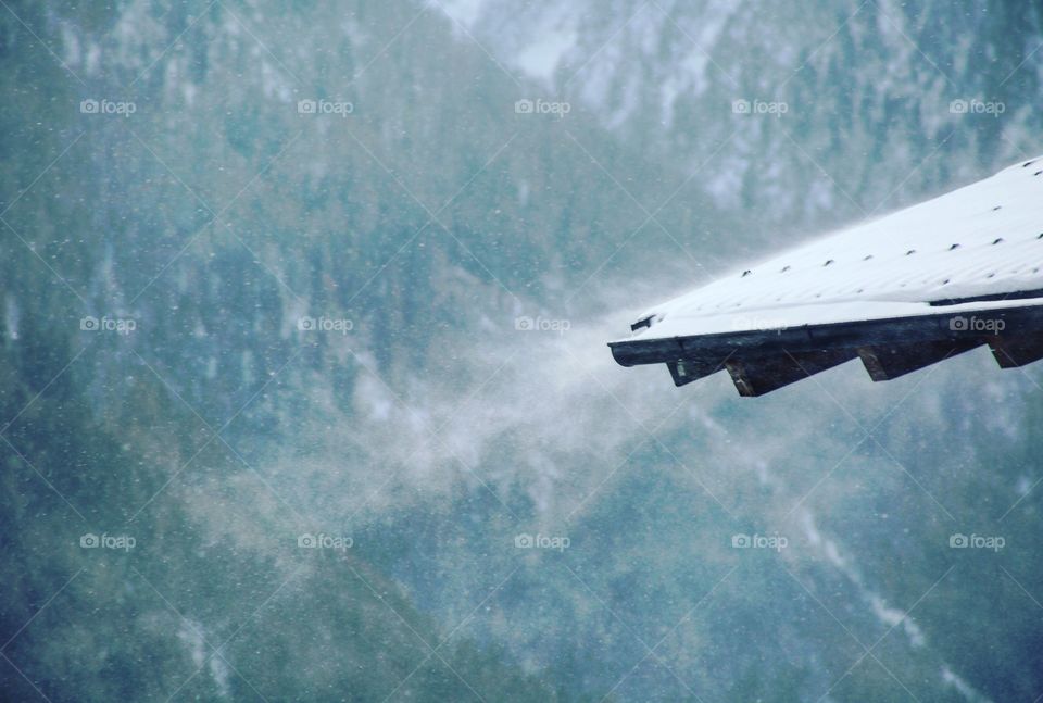 Snow blowing off of a roof in Austria.