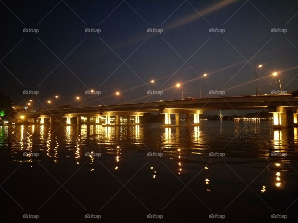 Light the bridge over the river at night.