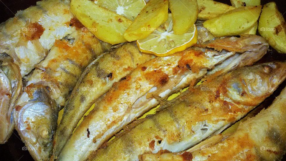 Fish and potato with lemon closeup. Homemade dish.
