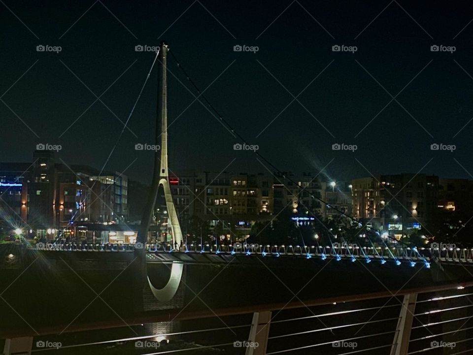 A bridge against a city skyline over dark water at night