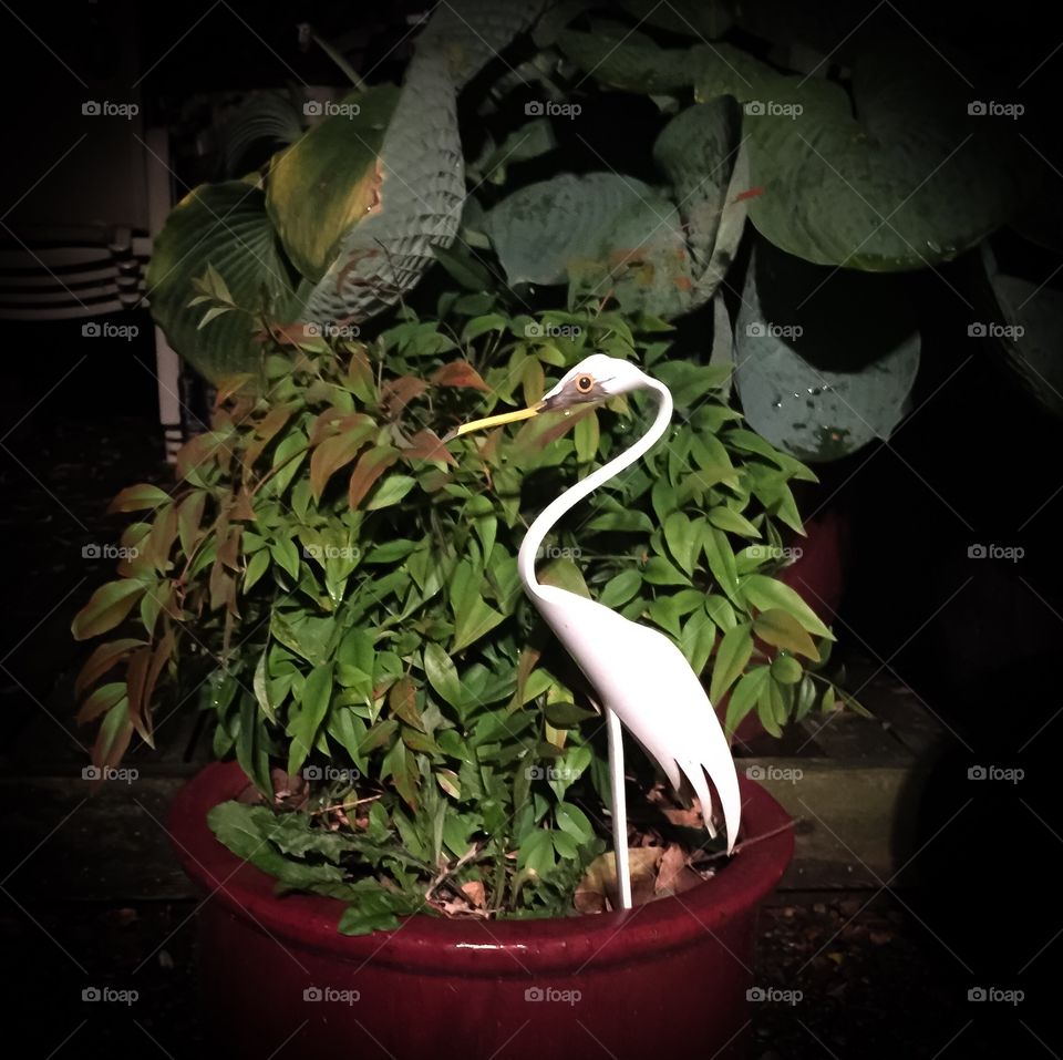 Metal art in the form of a Herron standing in the outdoor plant
