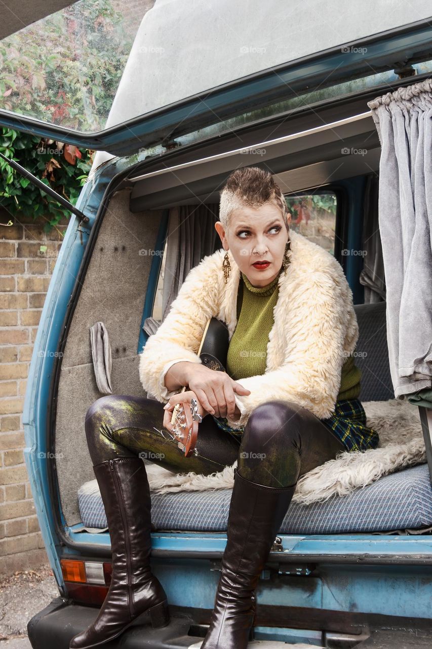 Punk Mum Debbie - mother of 5, sits with her guitar in a camper van