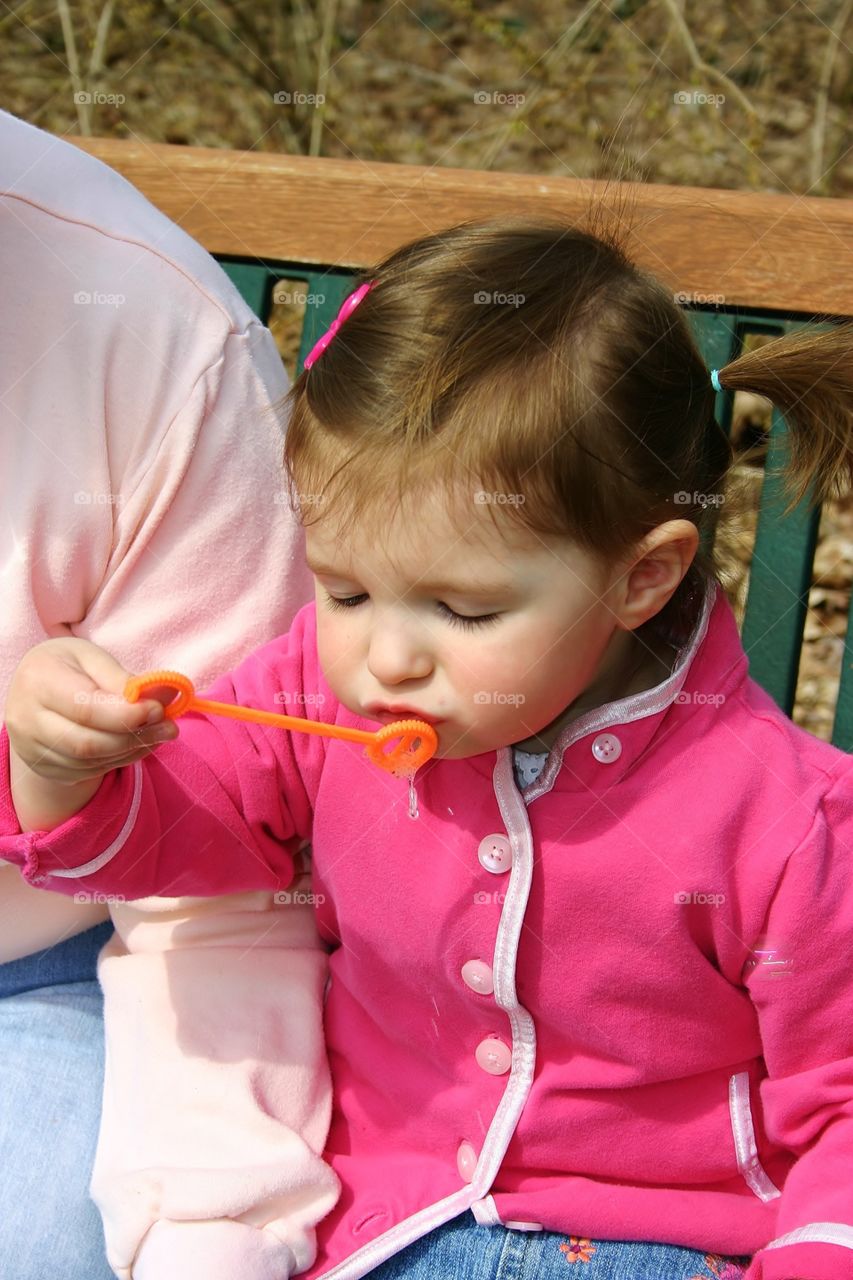 Blowing bubbles . She's trying so hard to blow a bubble - people enjoying spring mission 