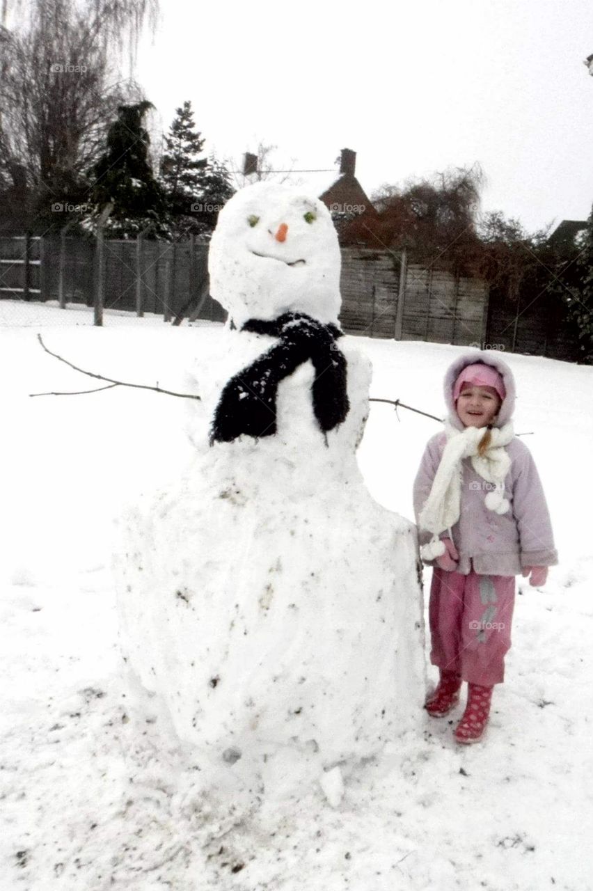 little girl and a big snow man