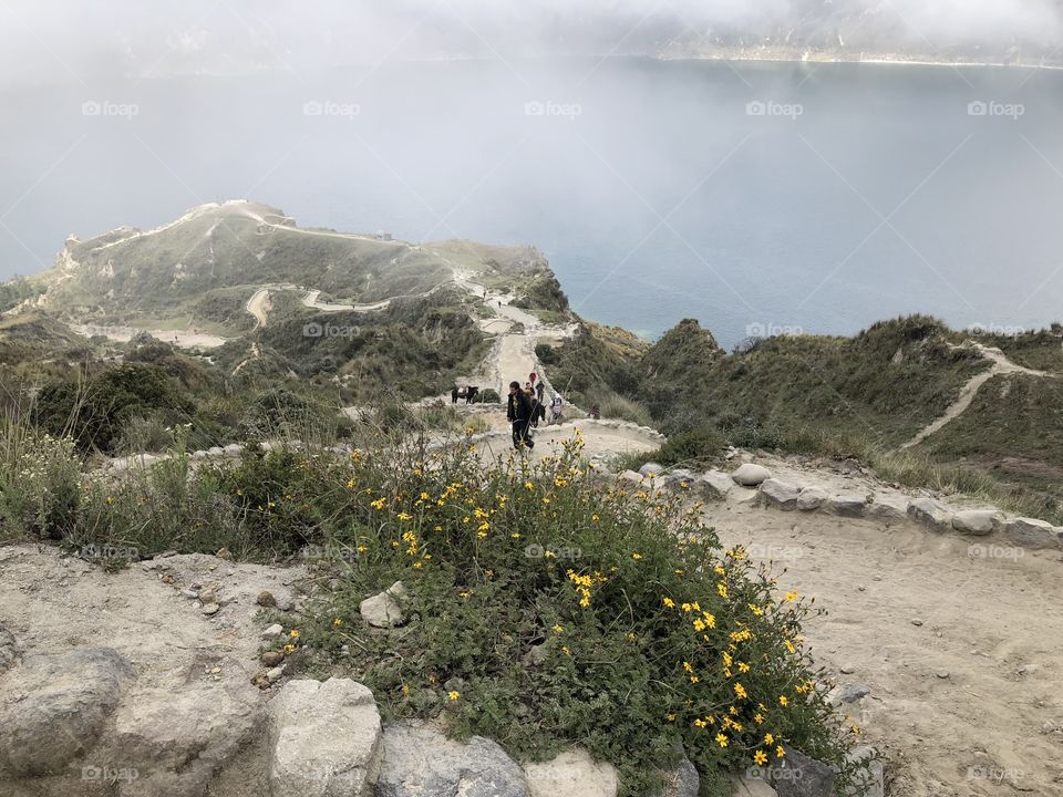 The descent down to the Quilotoa volcanic lagoon in Ecuador, clouds rolling in over the cool water.
