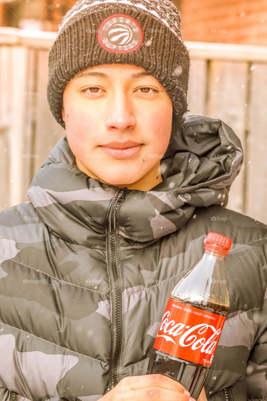 Happy teenager with a bottle of coca cola