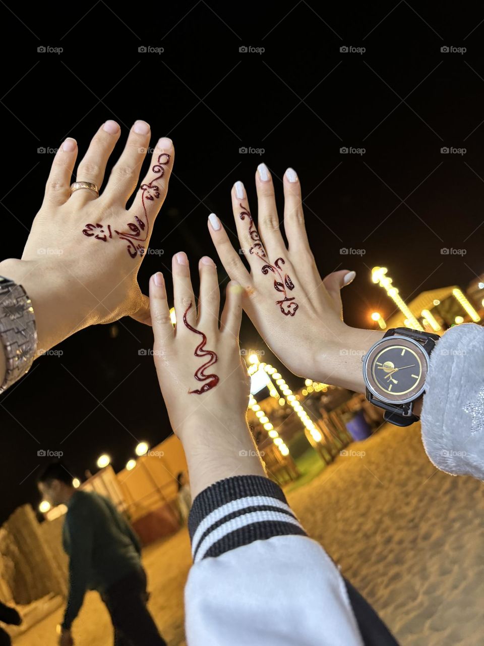 Hands with a pattern of henna in the moonlight