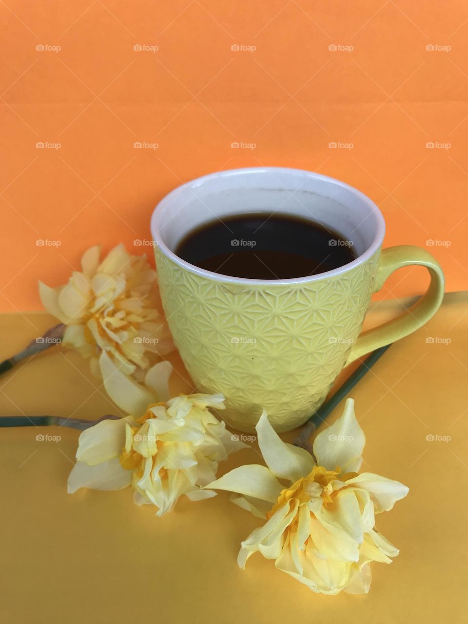 Yellow daffodils and a yellow cup of black coffee