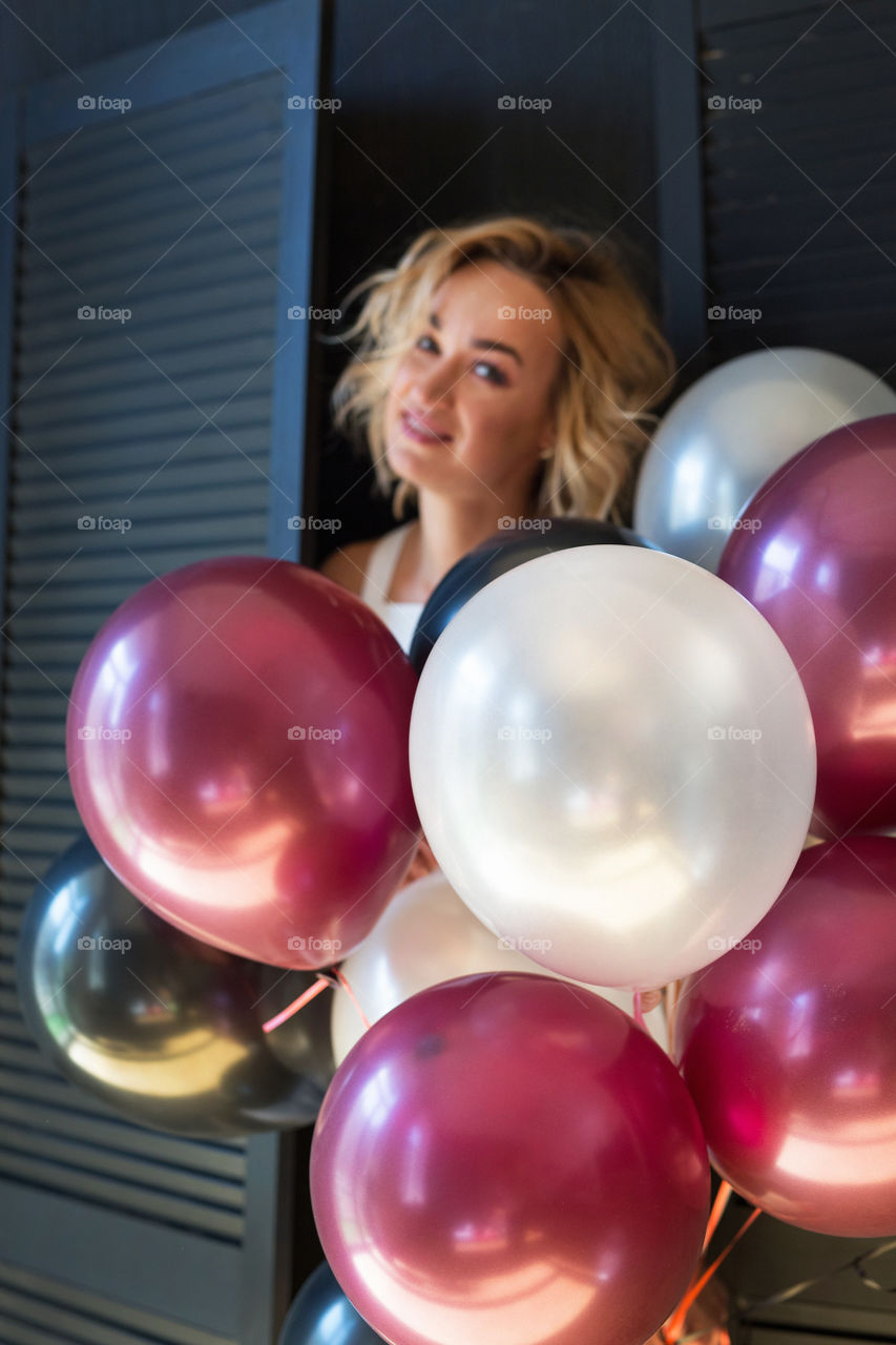 Happy sexy blond girl. Birthday girl. Girl walk at street with balloons 