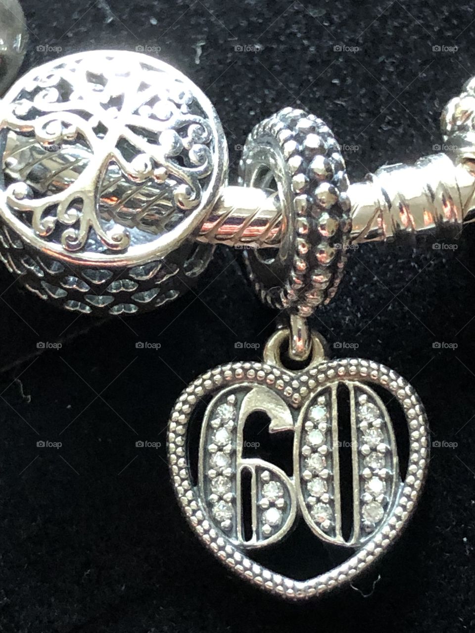 Close up of a panda bracelet with the tree of life and number 60 charm 