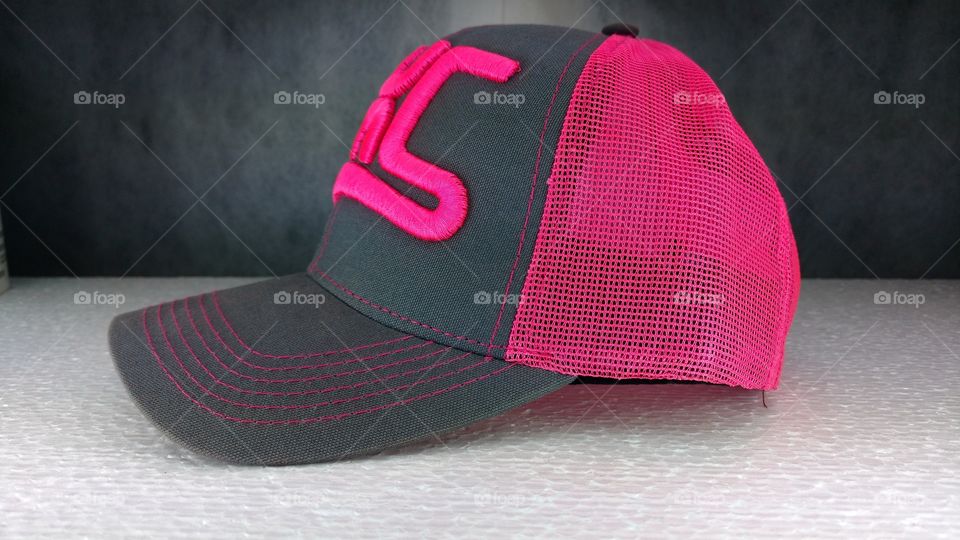 Boné, bordado magenta fluorescente com muito relevo.