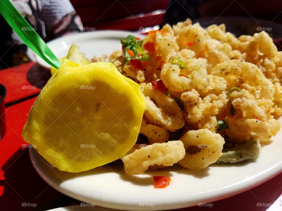 calamari garnished with red and green peppers with this side of lemon and yellow Mash.