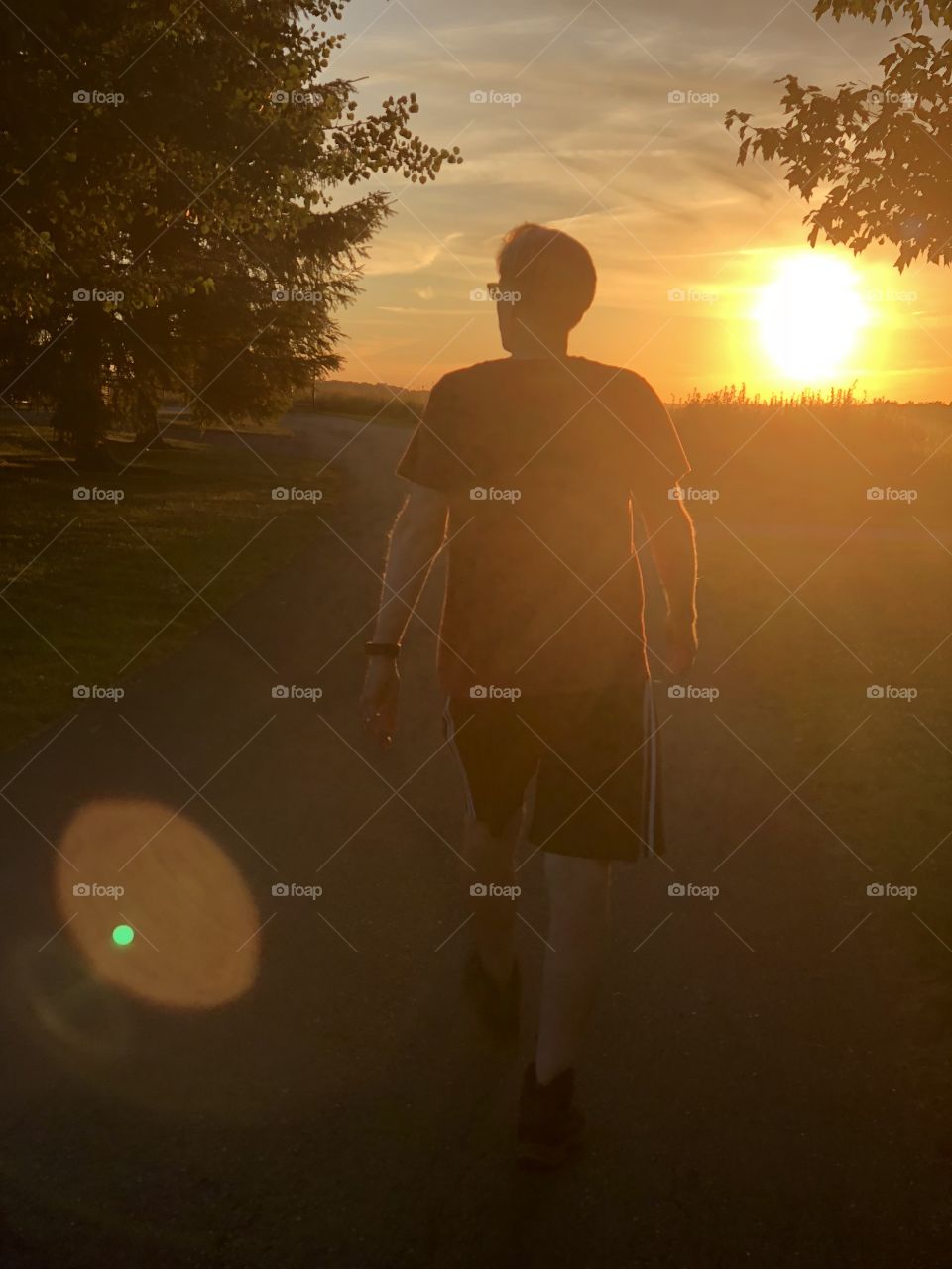 A guy walking in front of the sun set at a very bright point. It’s a darker image with the suns lighting the corner which adds a neat effect.