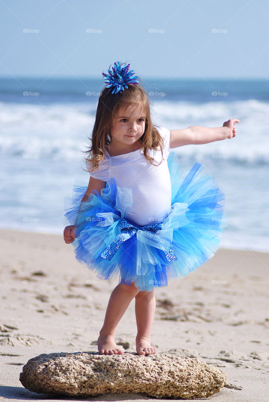 Girl dressed in tutu at beach