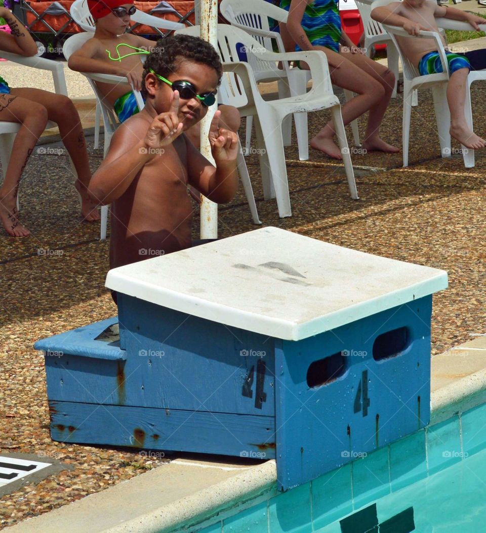 Shirtless boy in swimming goggles gesturing