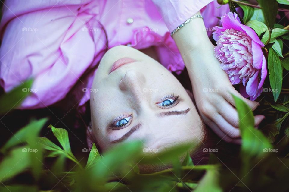 Close up portrait of young girl,  woman with blue eyes and pink dress without make up.