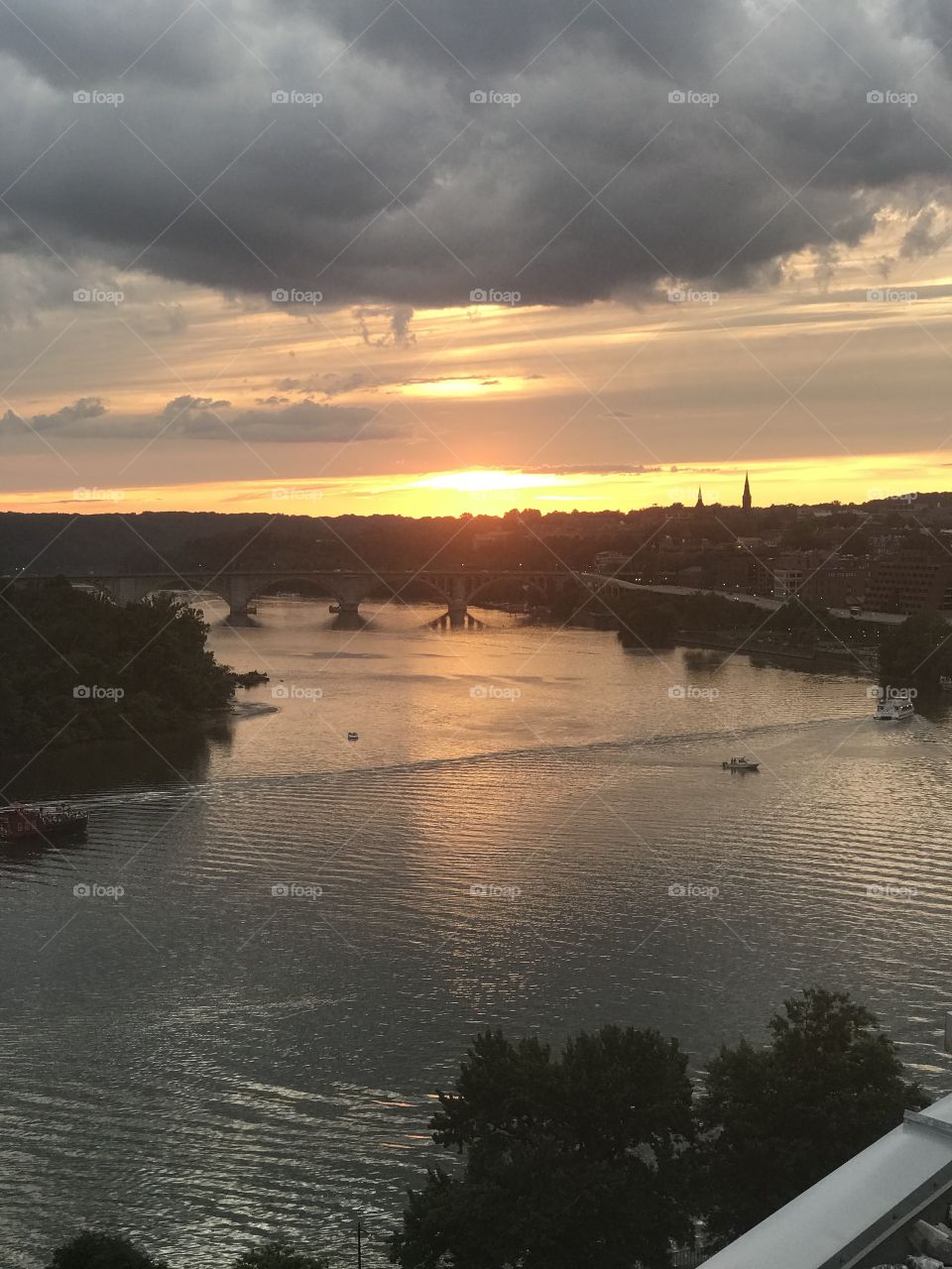 Beautiful sunset over the Potomac river. At dusk. You can see a bridge over the water. Calm, peaceful river with reflection. 