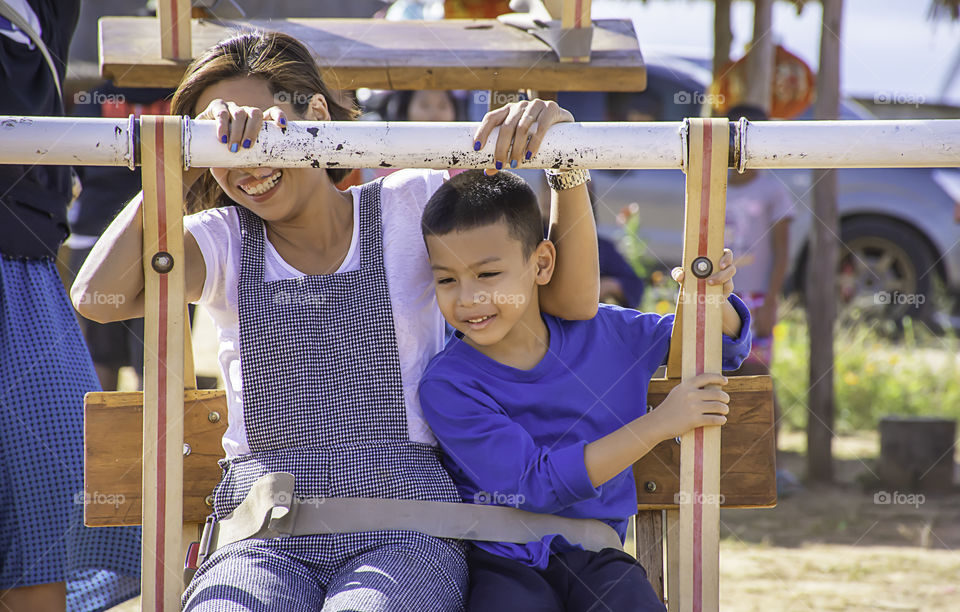 Mother and son on wooden Ferris wheel and bright blue sky at Windtime Khao kho , Phetchabun in Thailand.