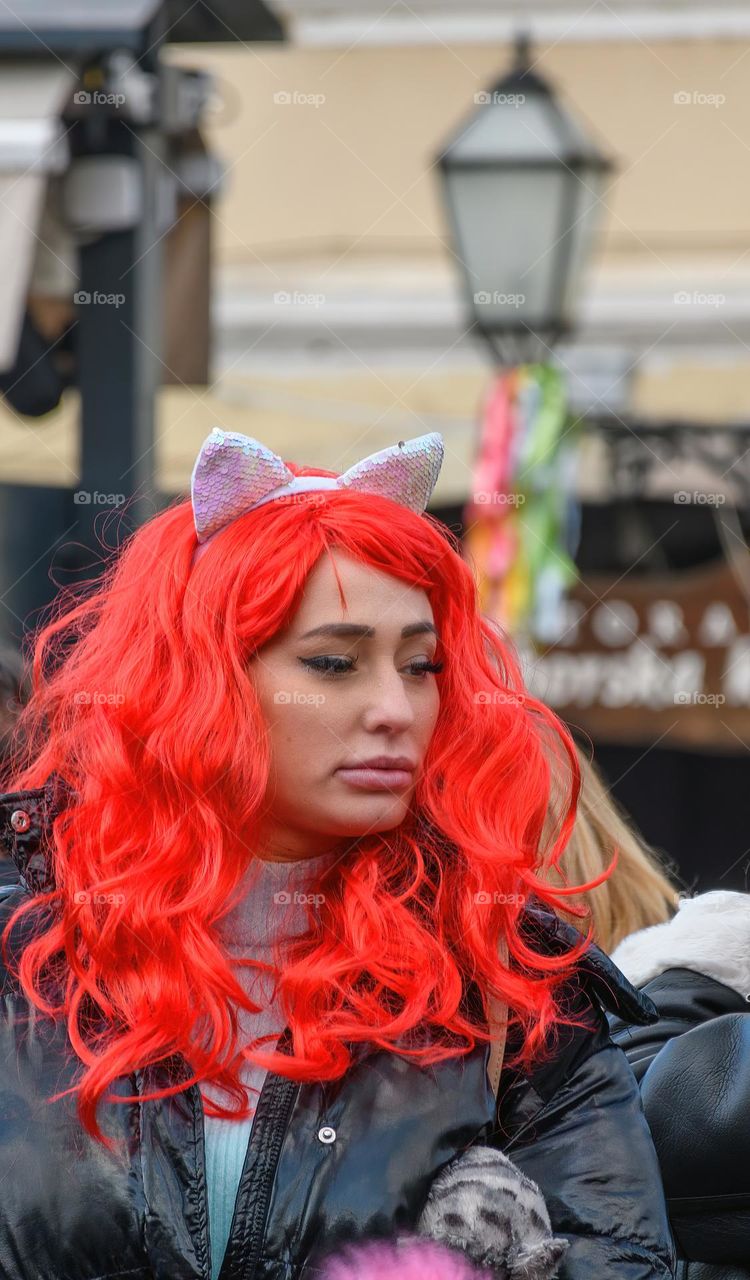 Portrait of attractive woman wearing a red wig at carnival