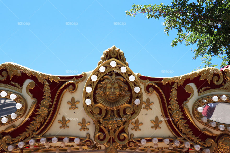 Carved, golden decor with lightbulbs on a vintage carousel