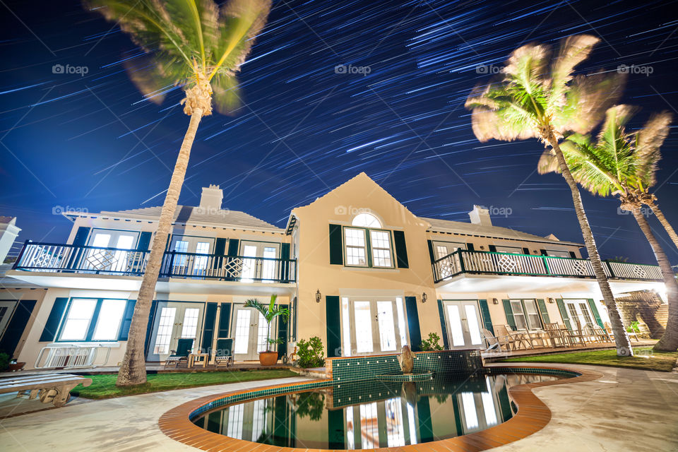 Star trails over a beautiful tropical property, a perspective showing the rotation of the earth.