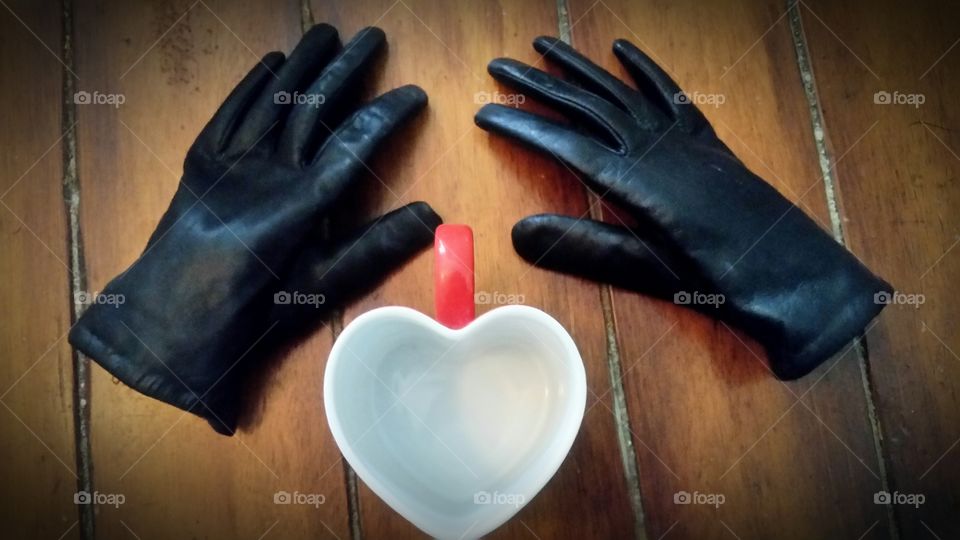 High angle view of hand gloves with heart shape cup