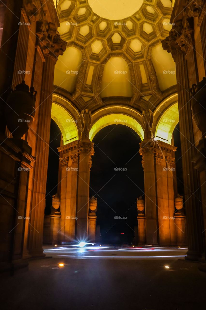 Palace of Fine Arts in San Francisco California at night under the dome with a light ring glowing at the base from motor scooters circling on a Friday night 