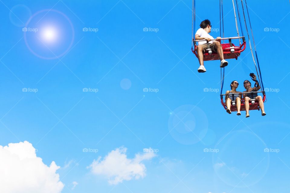 Friends enjoying swing at amusement park