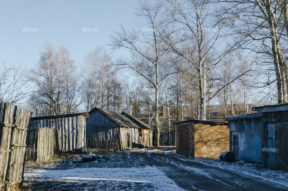 Rural street with garages and barns in village Krapivna, Russia 