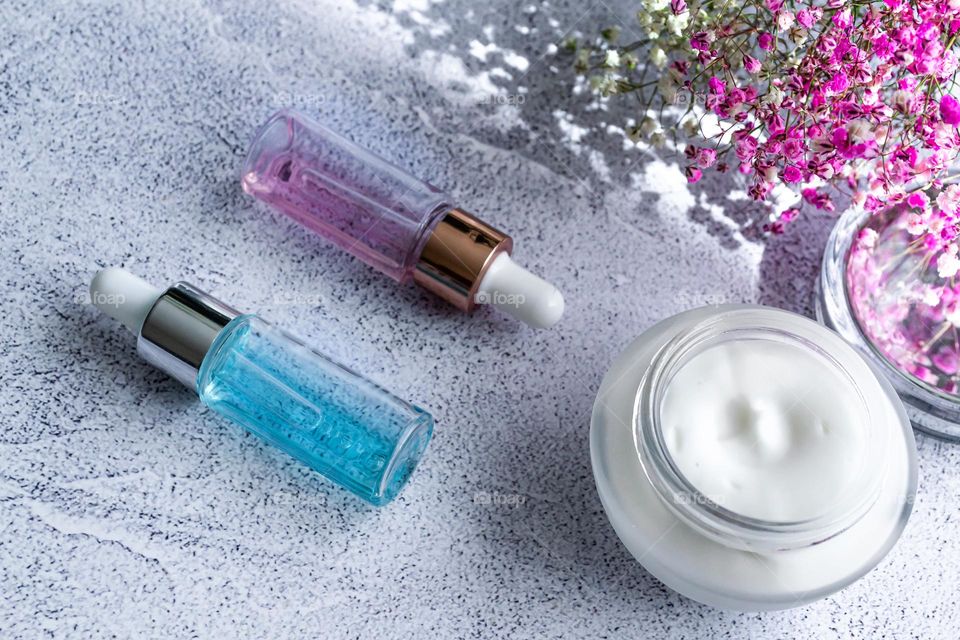 cosmetics serum and moisturizing face cream on marble gray background