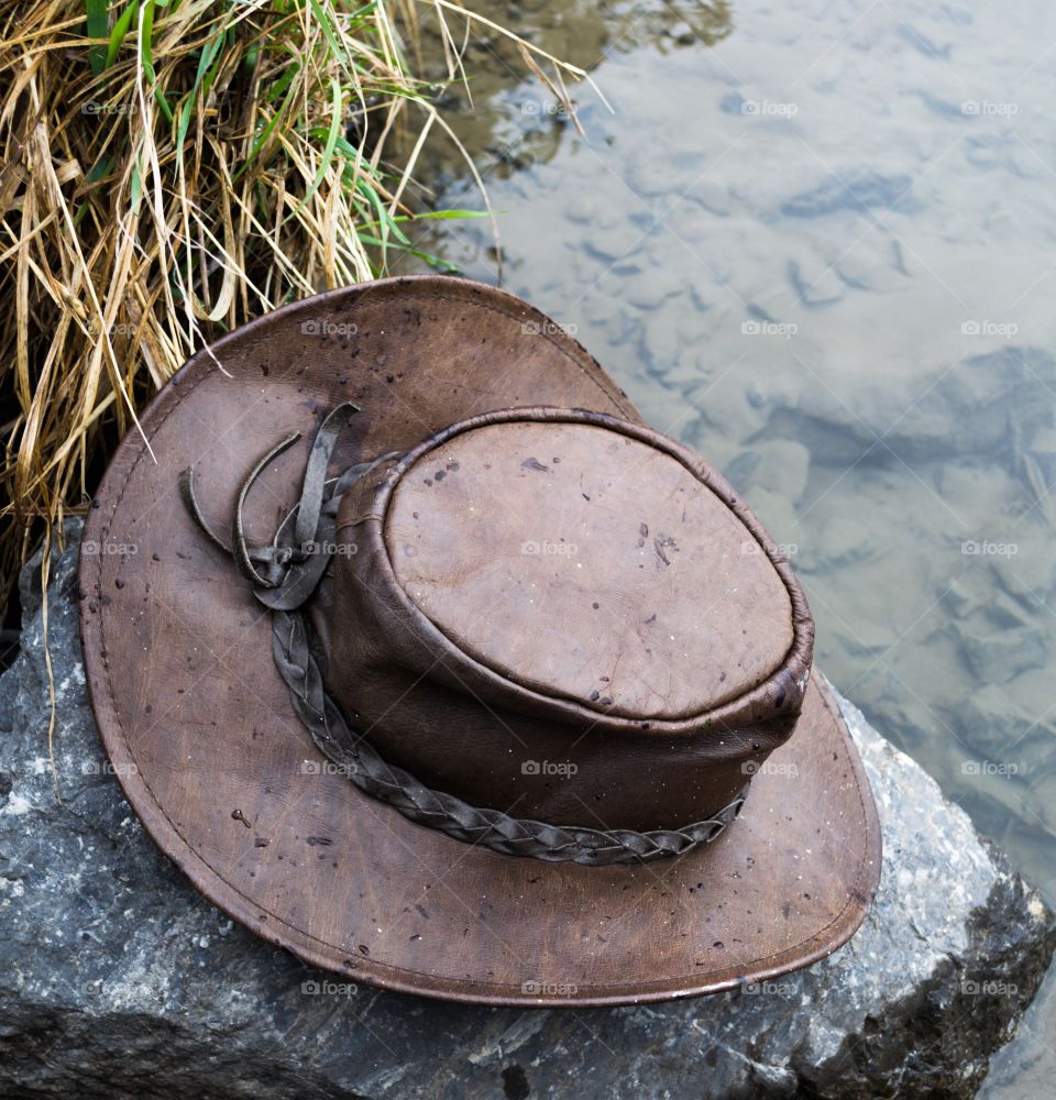 Leather cowboy hat resting on a rock in the wilderness in Canada's Rocky Mountains 