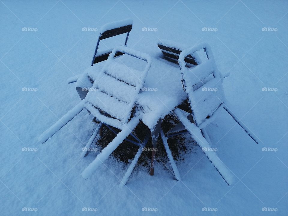 Chairs covered with snow