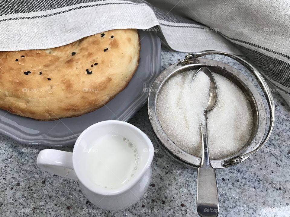 Cup of milk with sugar and bread