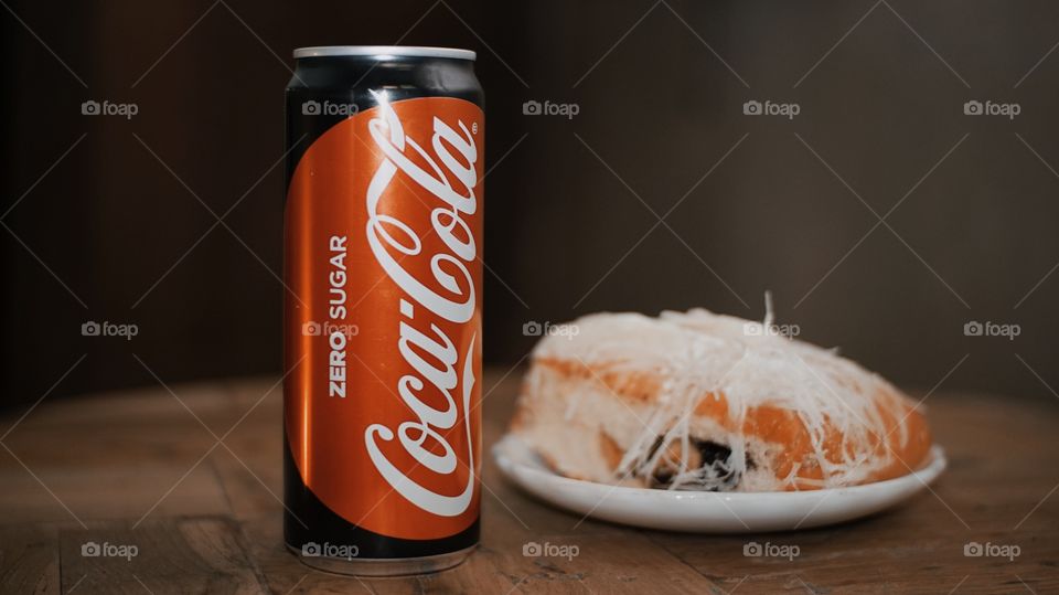 One can of Coca cola drink and chocolate bread with cheese topping