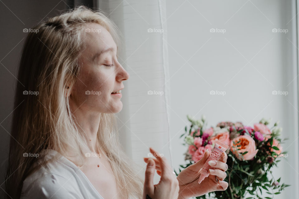 smiling woman using skin care product