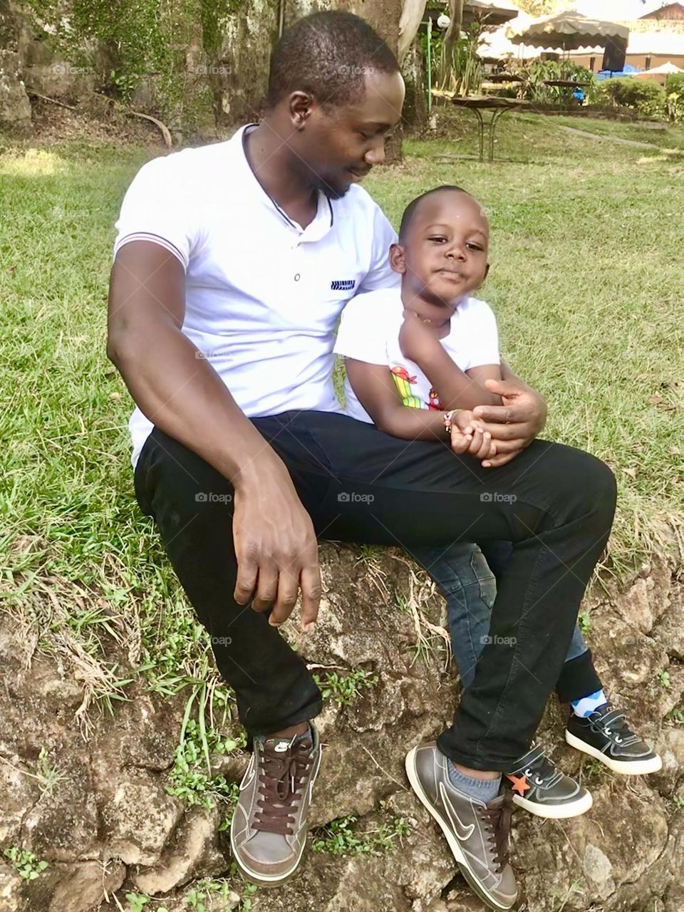 real people full length Sitting Males men casual clothing young men bonding day togetherness young adult mid adult men Love lifestyles leisure activity father family with one child Plant positive emotion outdoors in Thika , Kenya