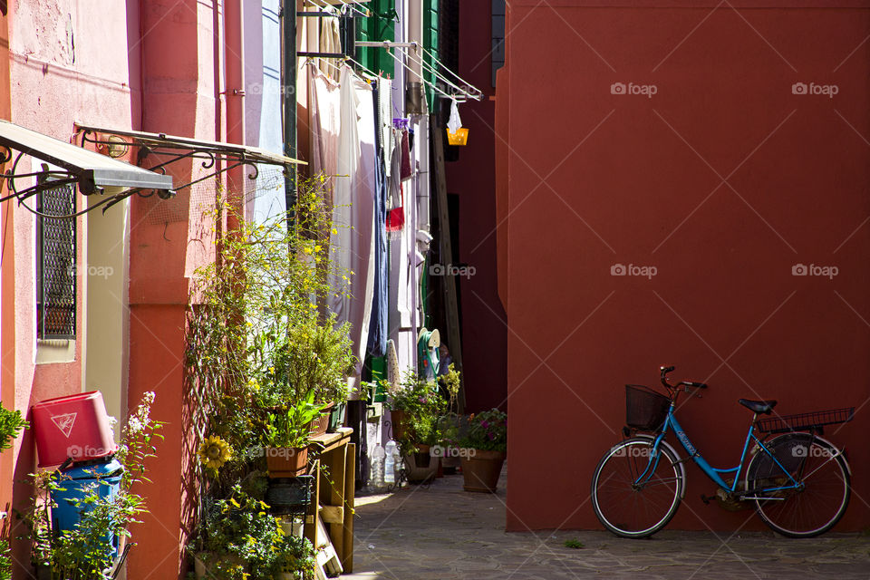 courtyard on the island of Burano. bicycle in the yard of houses with colored walls