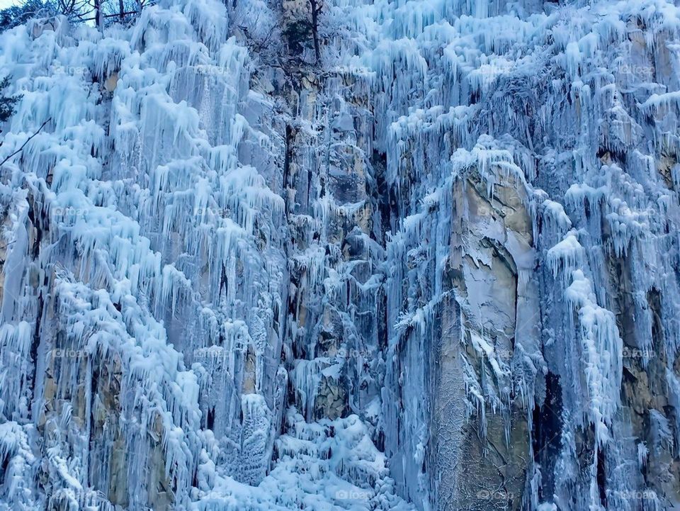 A water falls covered with snow.