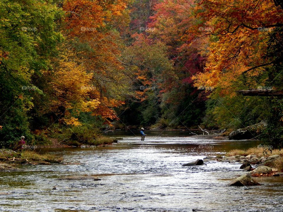 man fishing in the Chattooga river with beautiful fall colors