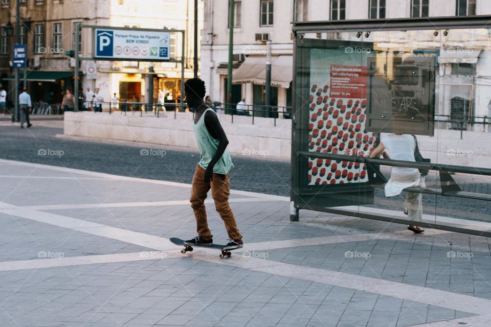 A young black guy skateboarding on a warm summer day